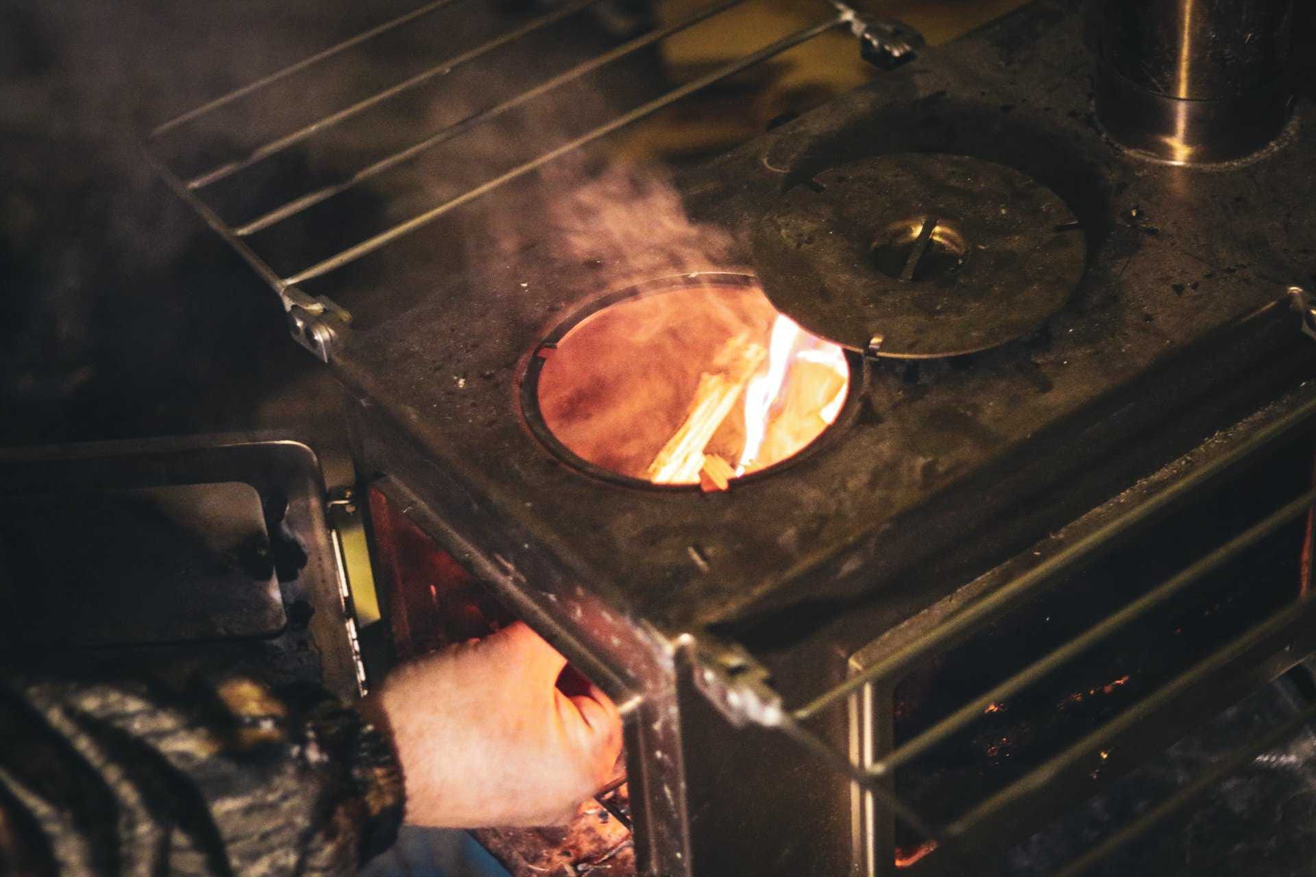 Adding wood to a tent stove Adding wood to a tent stove