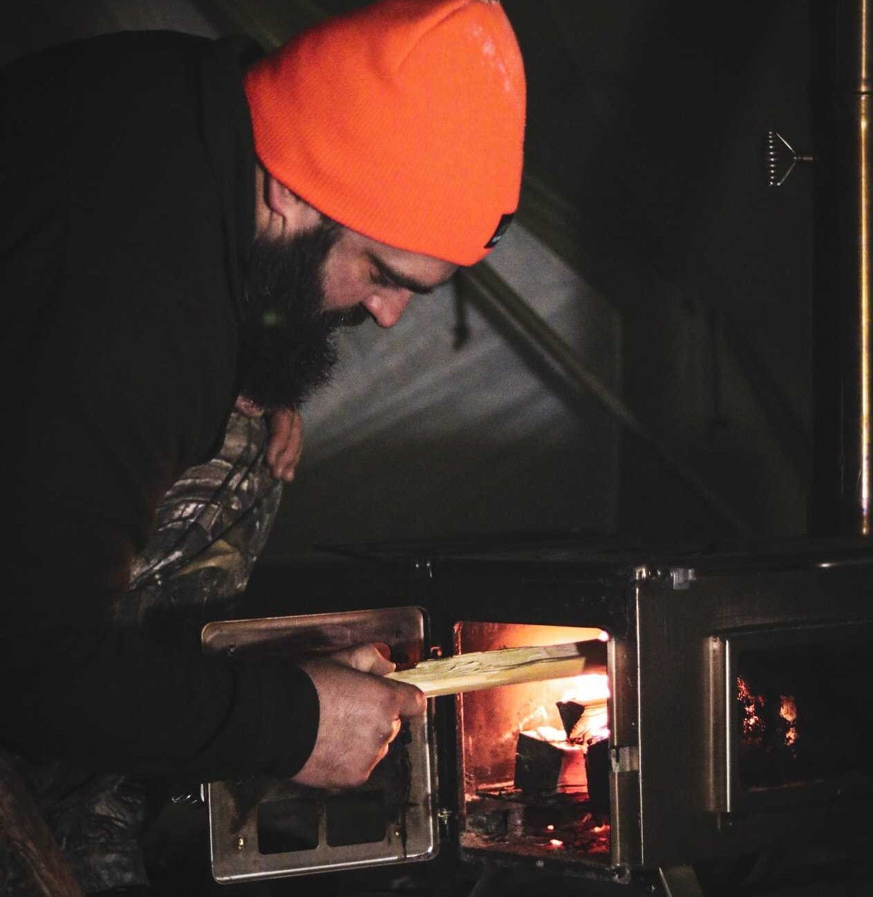 Loading tent stove with wood Loading tent stove with wood