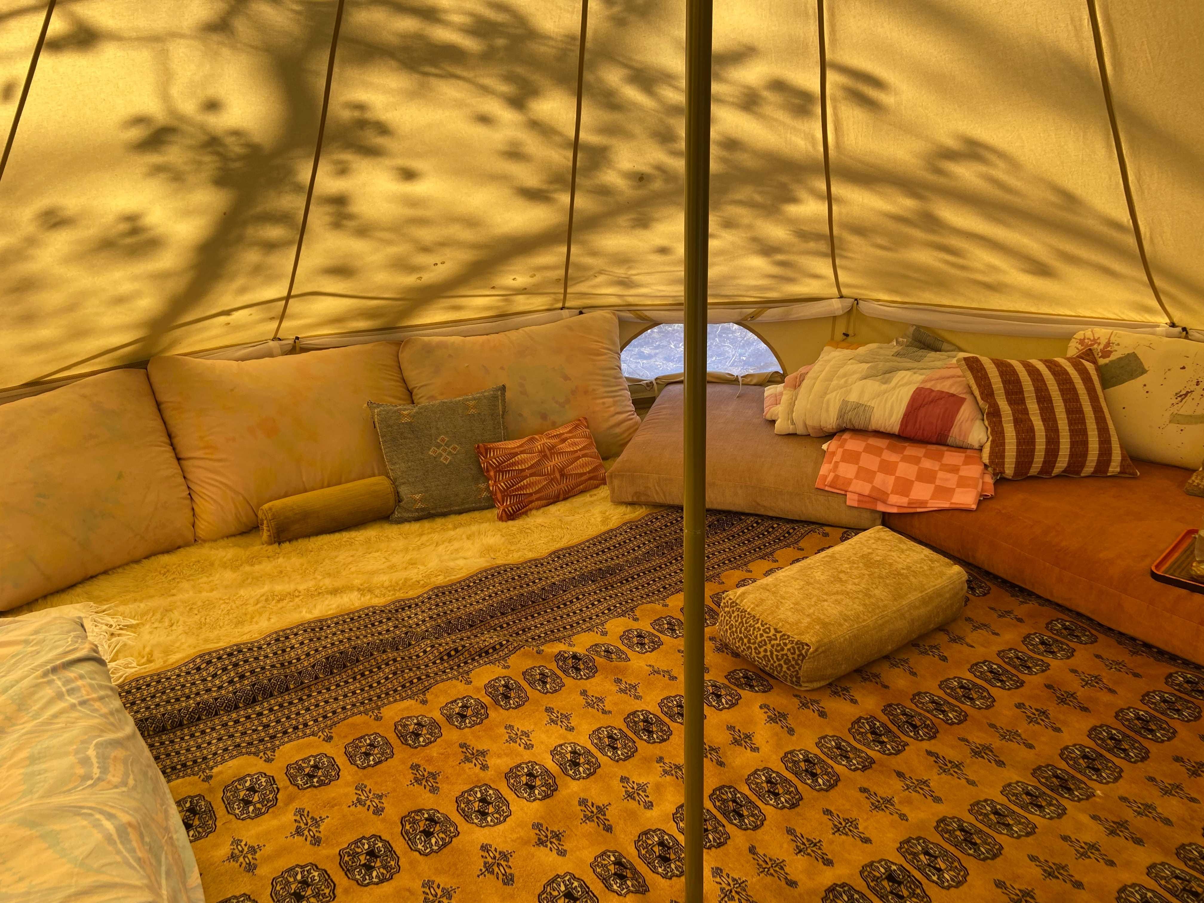 Louge area with lots of cushions setup inside a sibley canvas tent Louge area with lots of cushions setup inside a sibley canvas tent