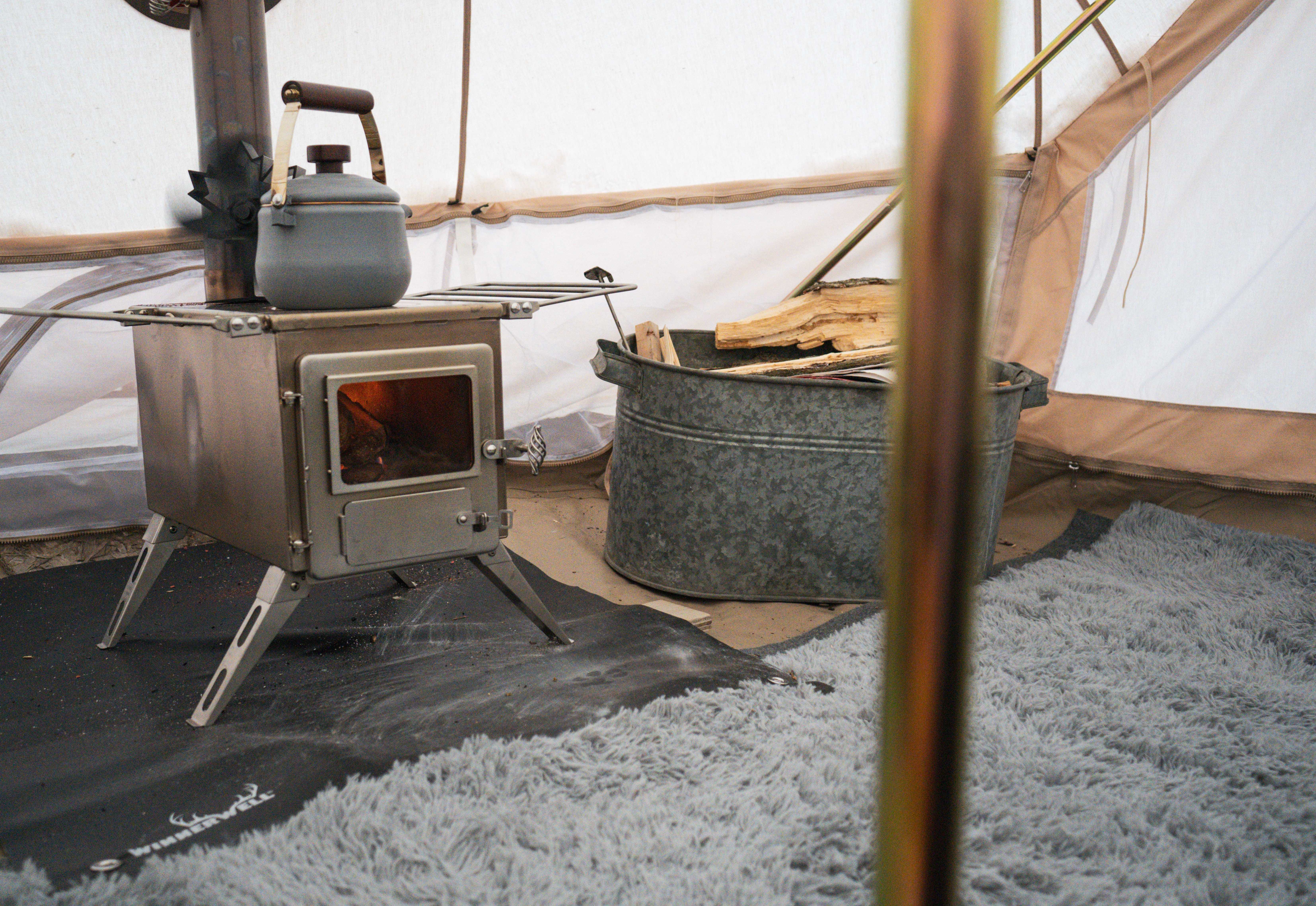 Tent stove setup on top of a fireproof mat Tent stove setup on top of a fireproof mat